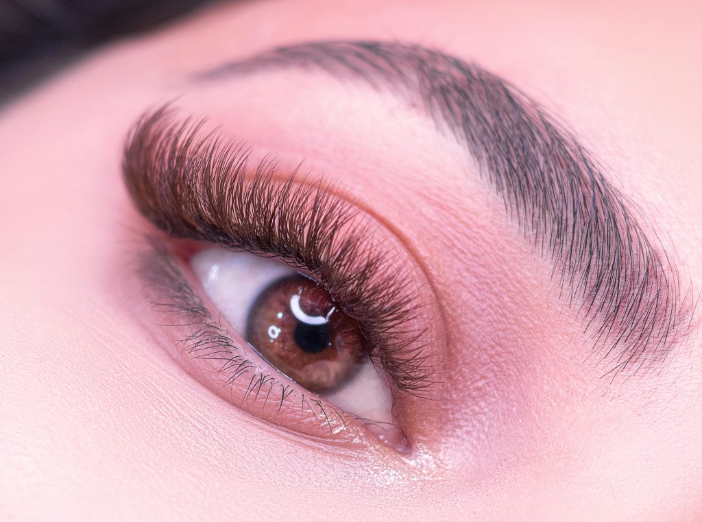 Detailed close-up of a woman's eye highlighting eyelashes and eyebrow.