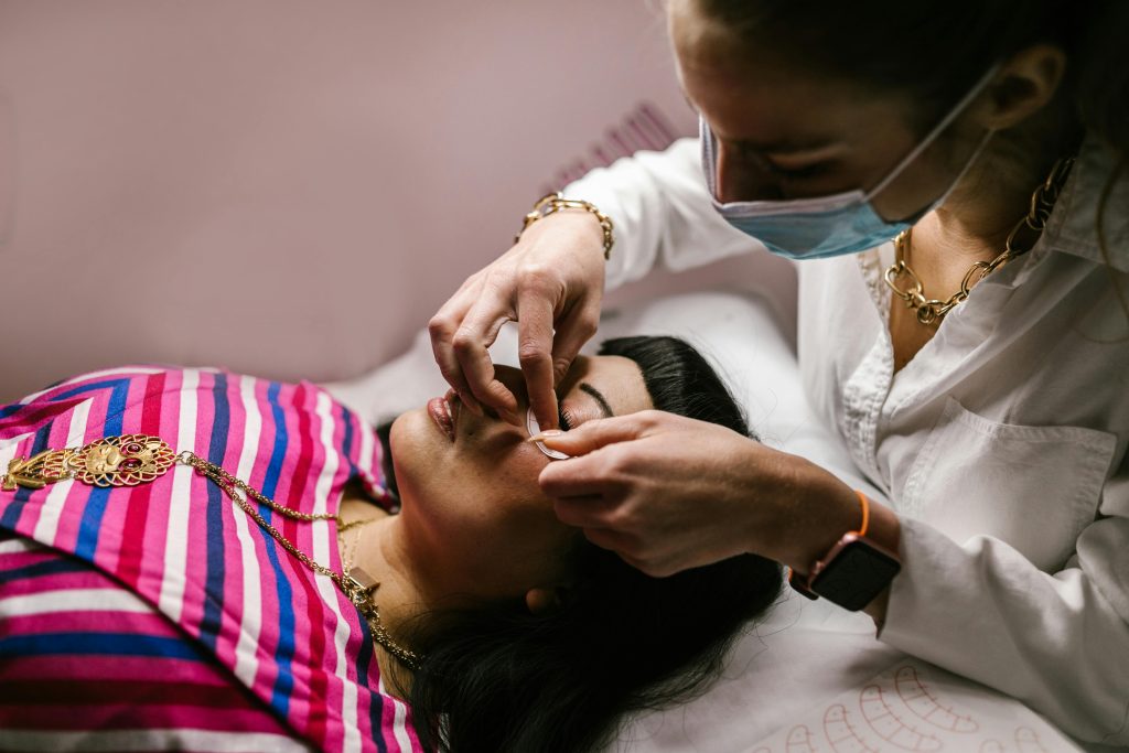 Woman receiving an eyebrow threading treatment in a tranquil spa environment.